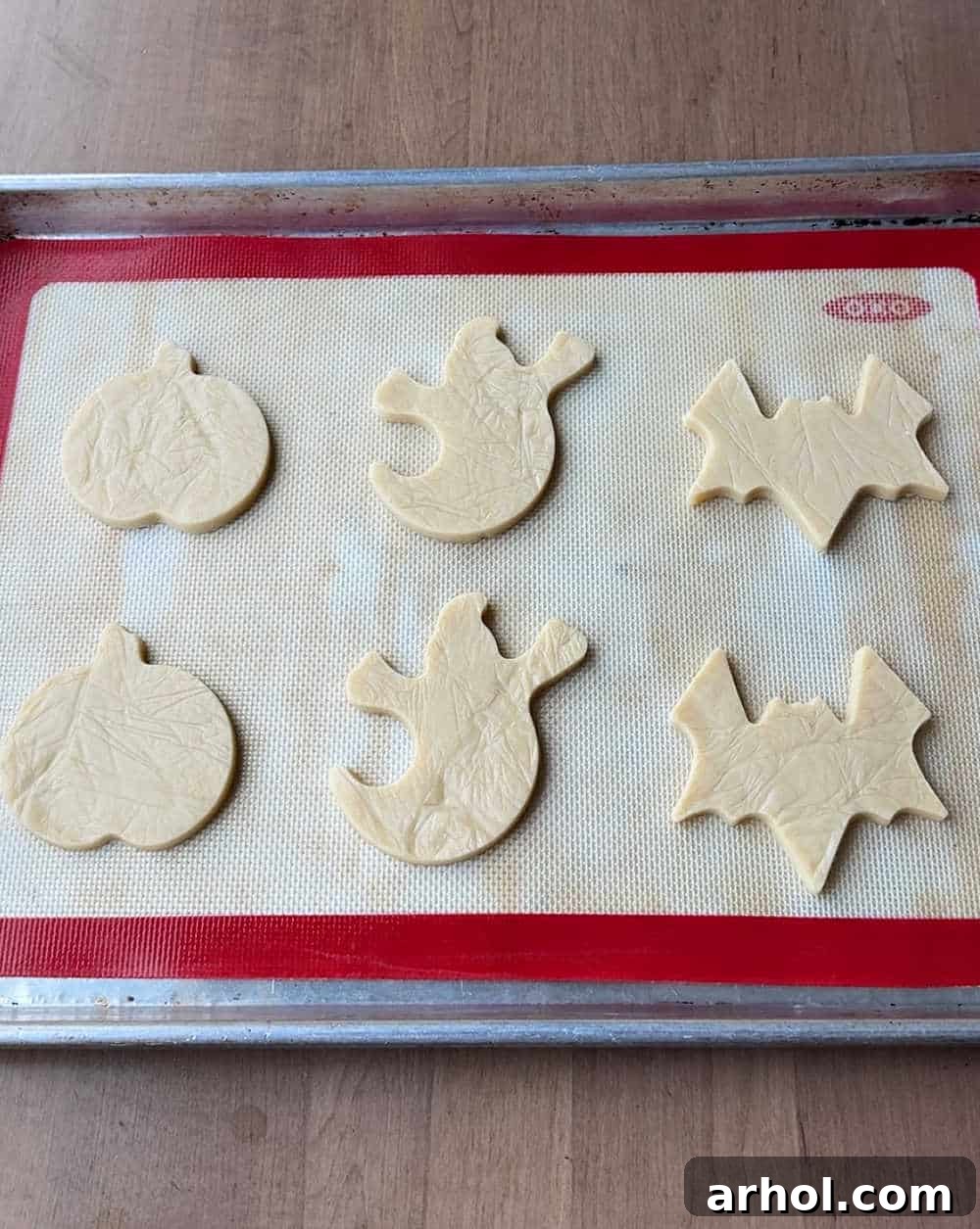 cookie dough cut-out shapes on baking pan.
