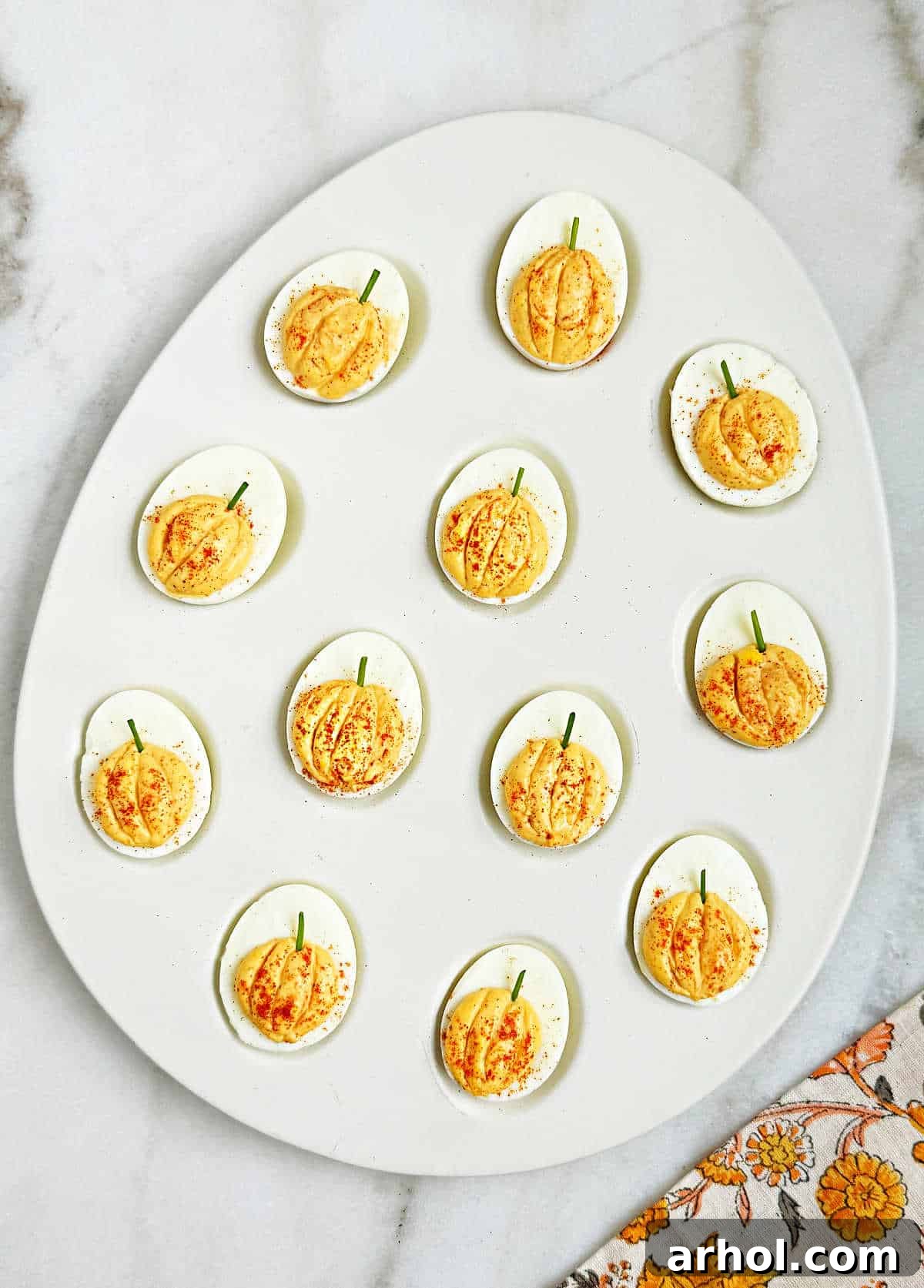 pumpkin deviled eggs in egg-shaped tray.