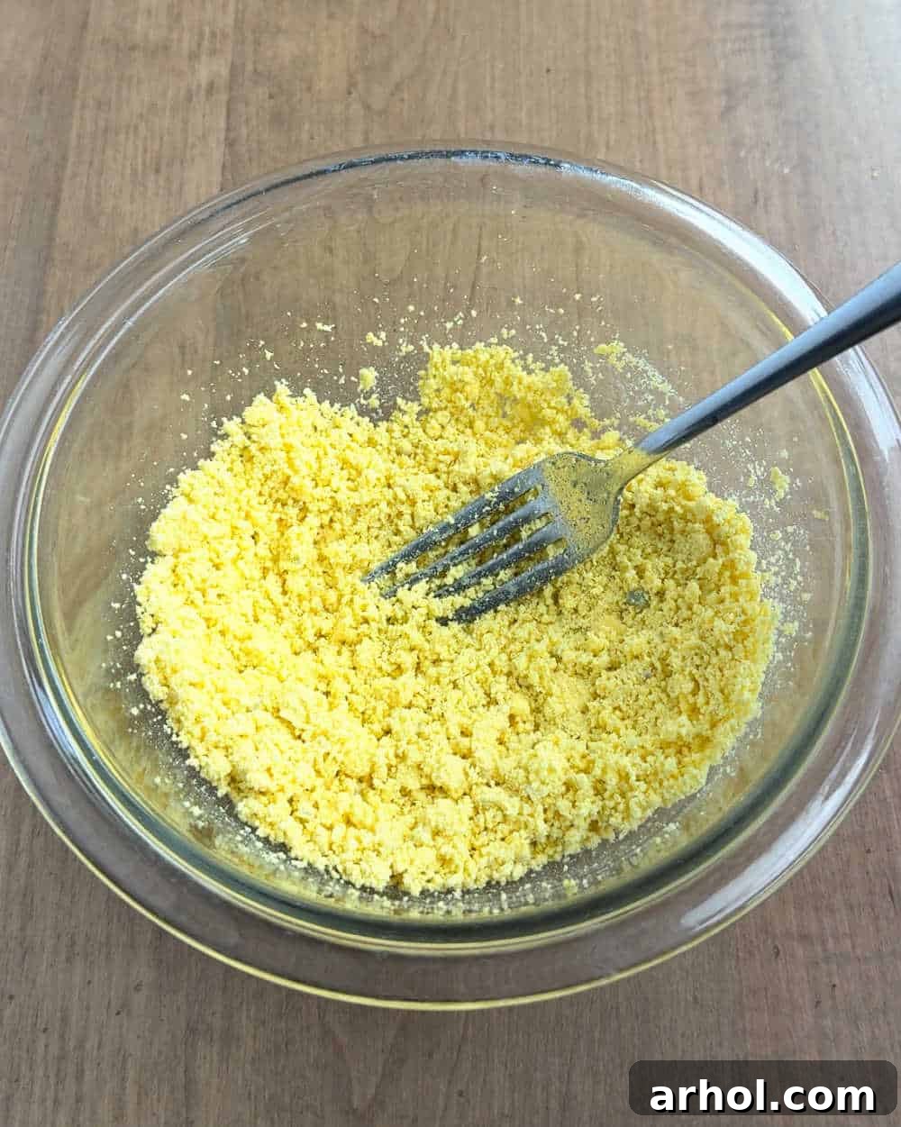 mashing egg yolks with fork.