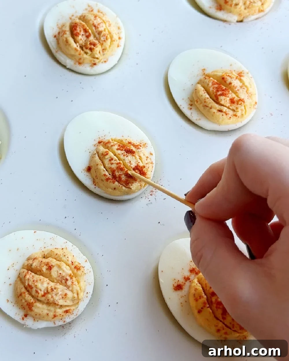 making grooves in egg yolk with toothpick.
