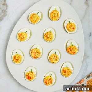 pumpkin deviled eggs in serving dish.