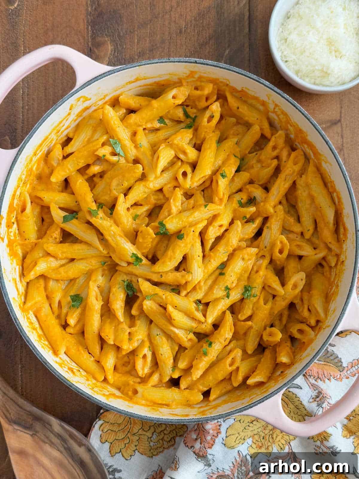 Effortless Pumpkin Pasta Perfection 2 Penne pasta generously coated with a vibrant pumpkin pasta sauce, garnished with fresh parsley, served in a rustic Dutch oven, ready to be enjoyed.