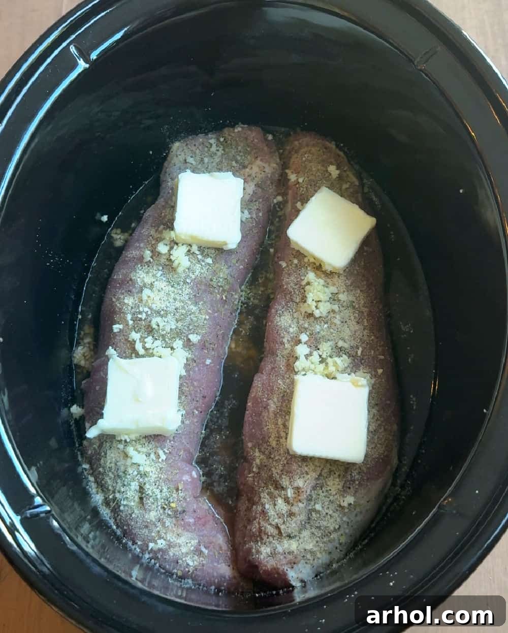 pats of butter on pork in crockpot.