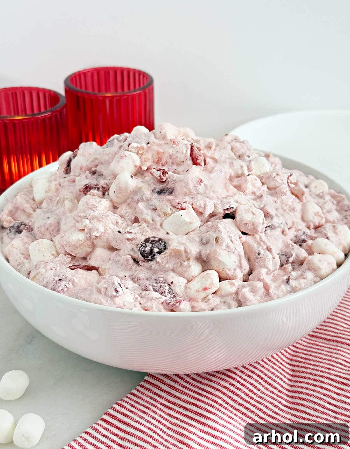 A beautifully presented bowl of homemade Cranberry Fluff on a rustic wooden table, garnished with fresh cranberries, perfect for a holiday feast.