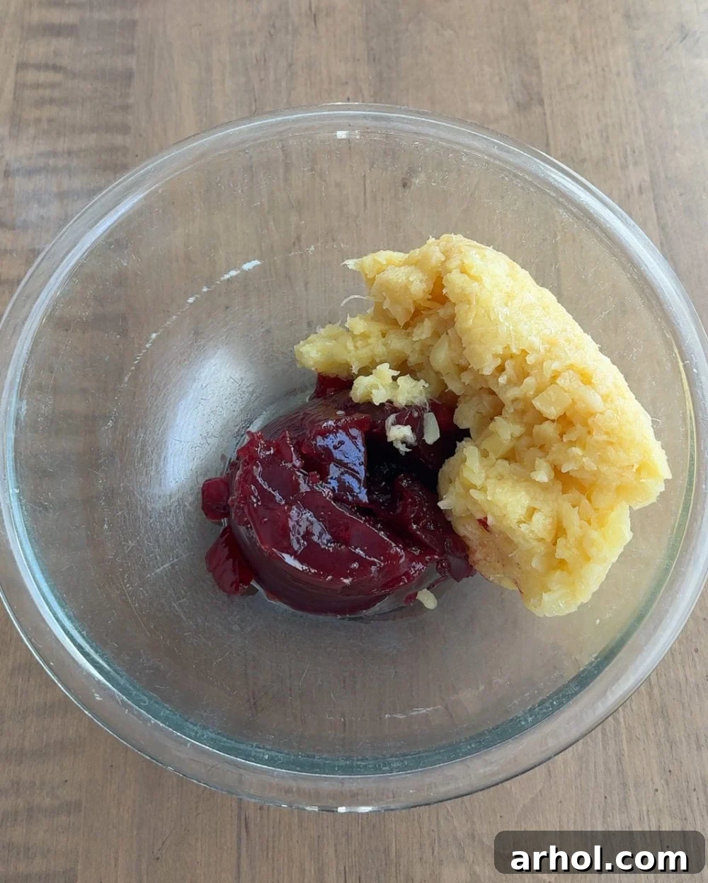 Drained crushed pineapple and whole berry cranberry sauce combined in a large mixing bowl, showing the initial stage of preparing cranberry fluff.