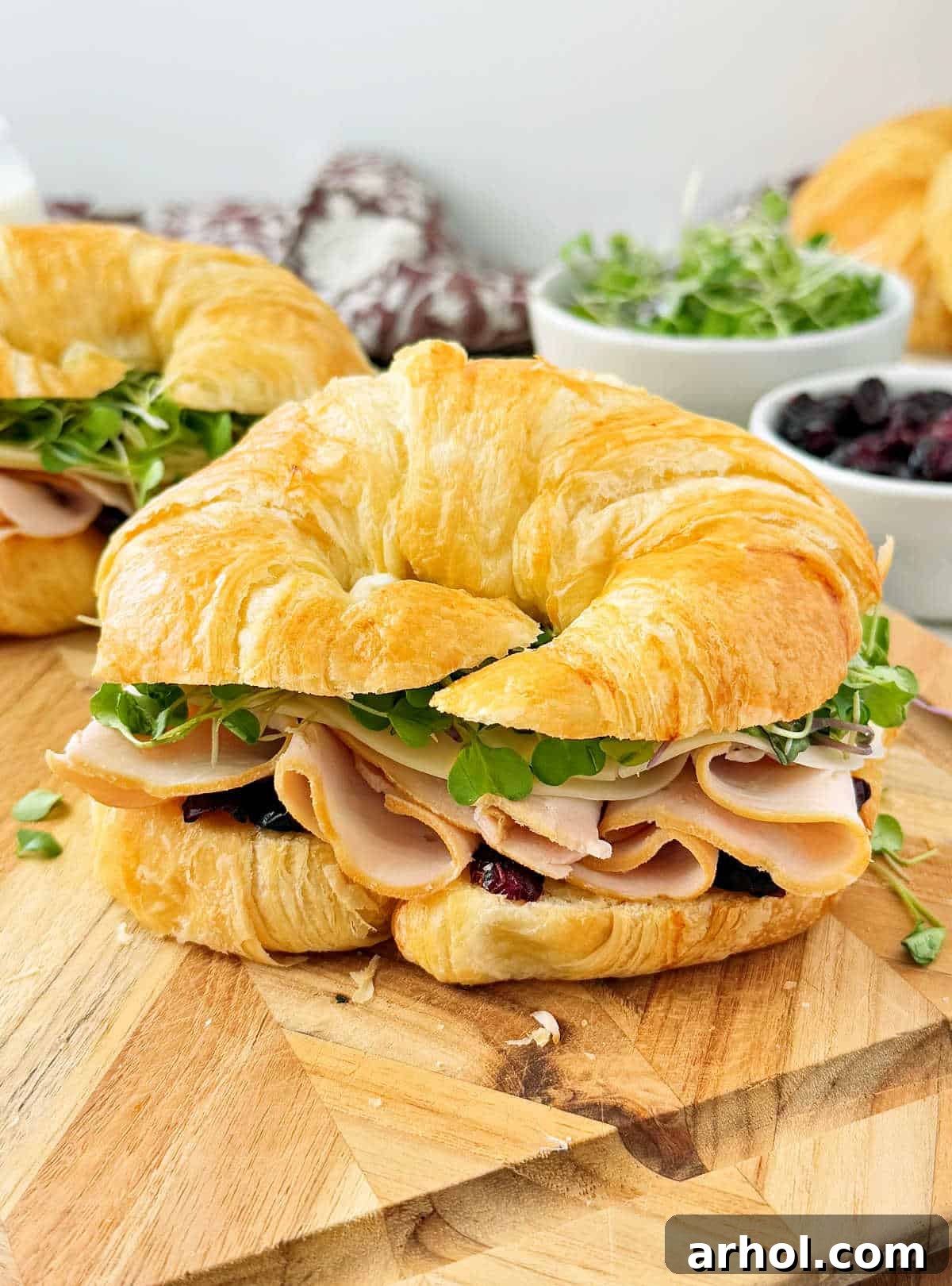 turkey croissant sandwich on cutting board.