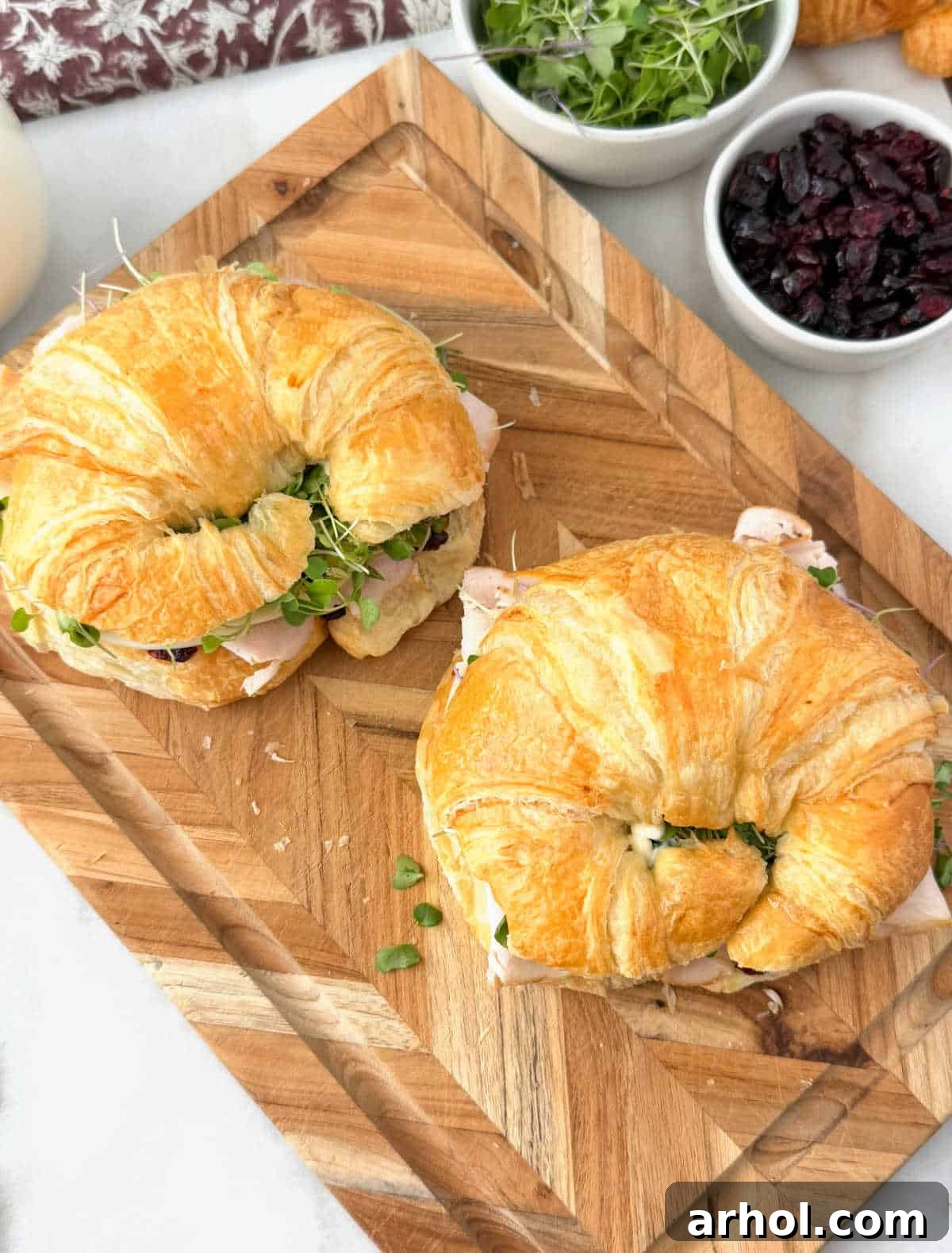 turkey croissant sandwiches on a cutting board.
