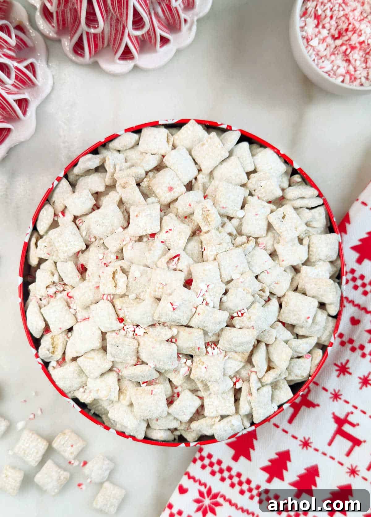 A bowl overflowing with festive peppermint puppy chow, generously sprinkled with crushed candy canes, ready to be enjoyed as a holiday treat.