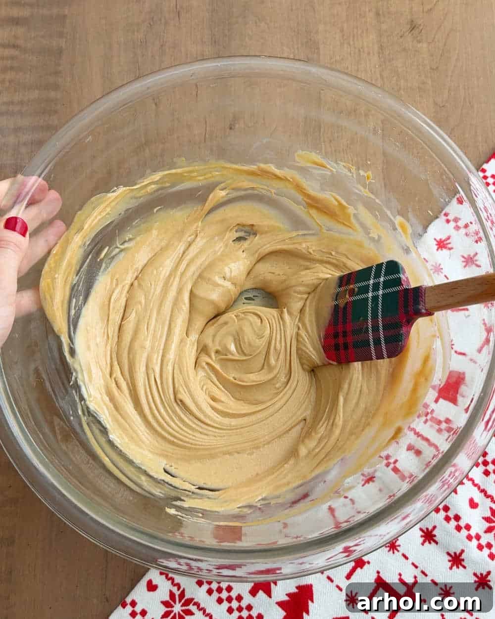 Close-up of creamy peanut butter and white chocolate melting together in a bowl, ready to be mixed for peppermint puppy chow.