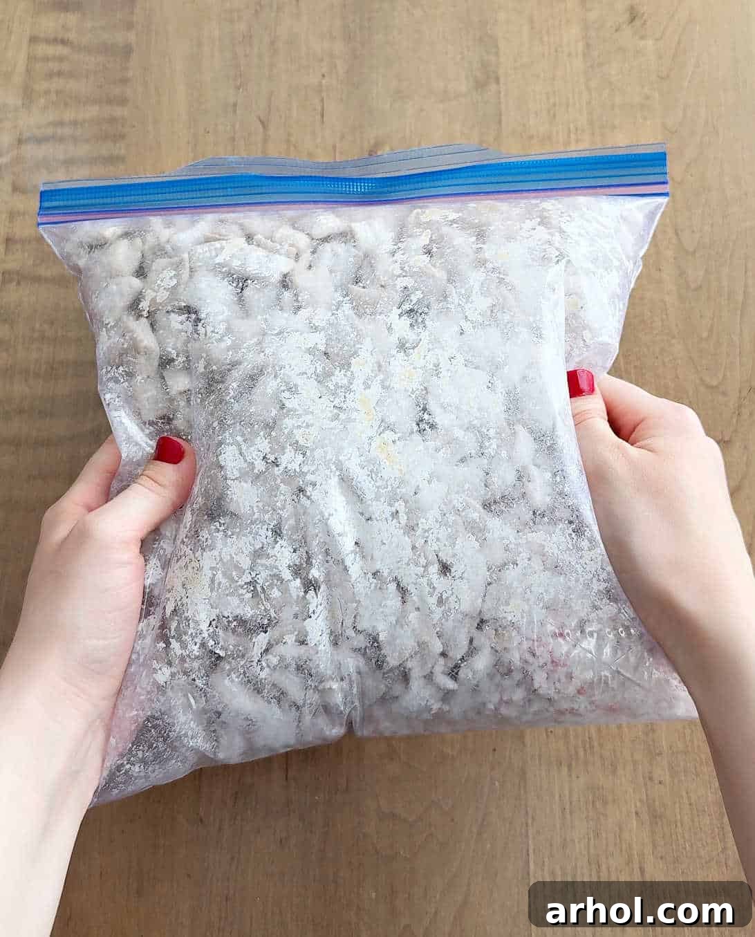 A large freezer bag being vigorously shaken, ensuring the chocolate-covered cereal is fully coated with powdered sugar and crushed candy canes for peppermint puppy chow.