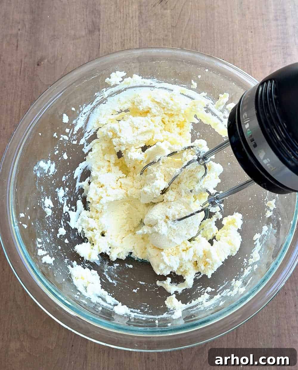 Spoonable Tiramisu Dream 5 The first step in making tiramisu dip: a close-up of mascarpone and softened cream cheese being creamed together in a mixing bowl with an electric mixer.