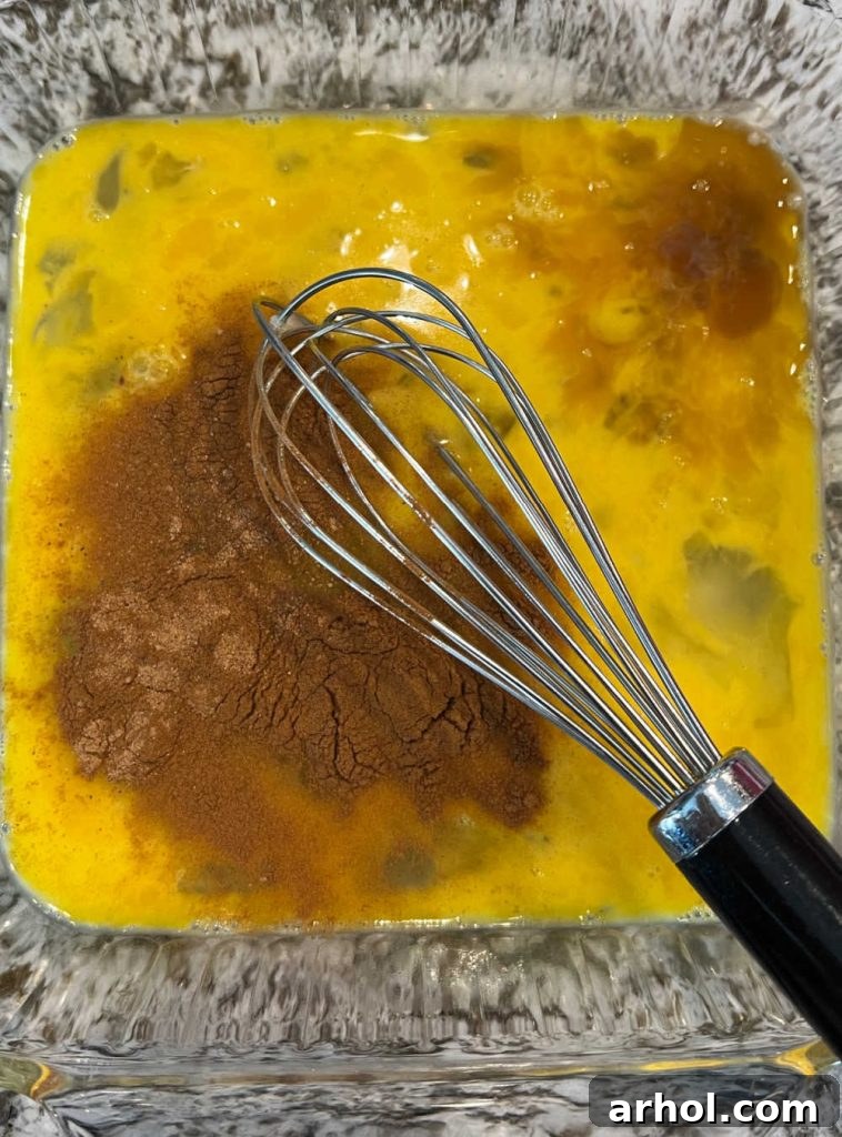 Spiced Eggnog French Toast 3 Beaten eggs with cinnamon and vanilla extract in a shallow baking dish, ready for eggnog.