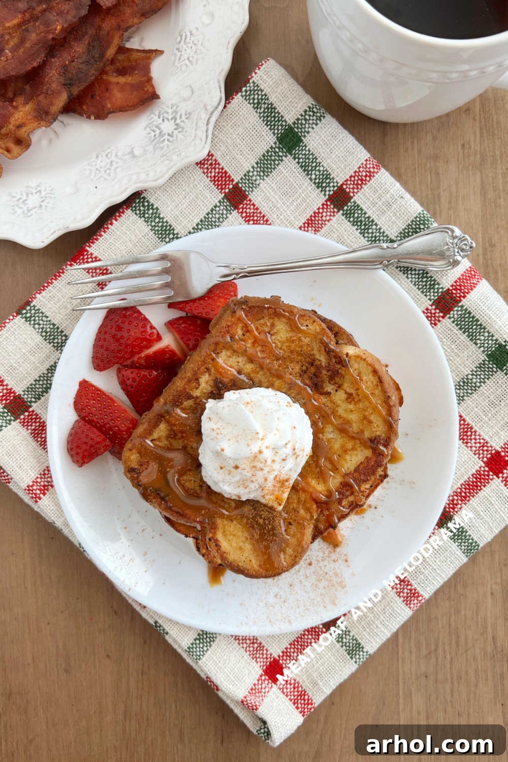 Spiced Eggnog French Toast 6 A festive holiday breakfast featuring Eggnog French Toast with crispy bacon and a cup of coffee on a beautifully set table.