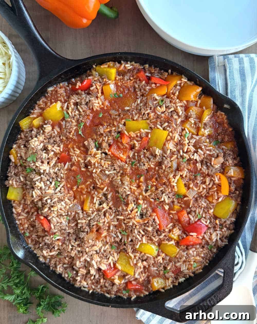 A close-up of a deconstructed stuffed pepper skillet, garnished with fresh green parsley, ready to be served.