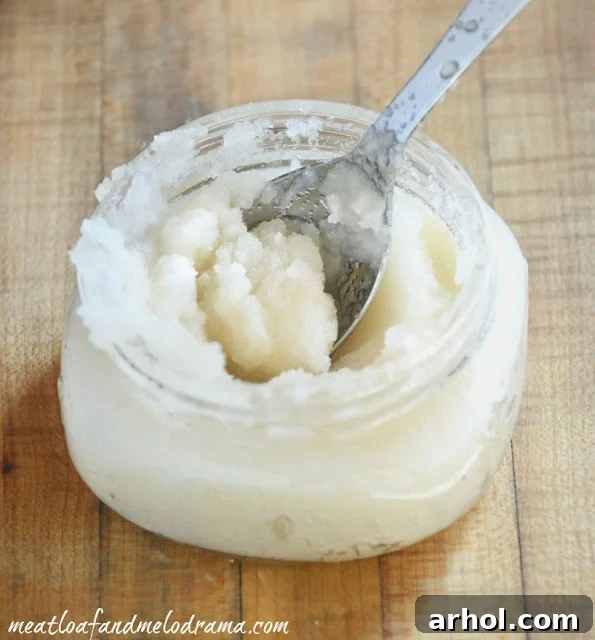 Hands mixing ingredients for a homemade sugar scrub in a glass bowl.