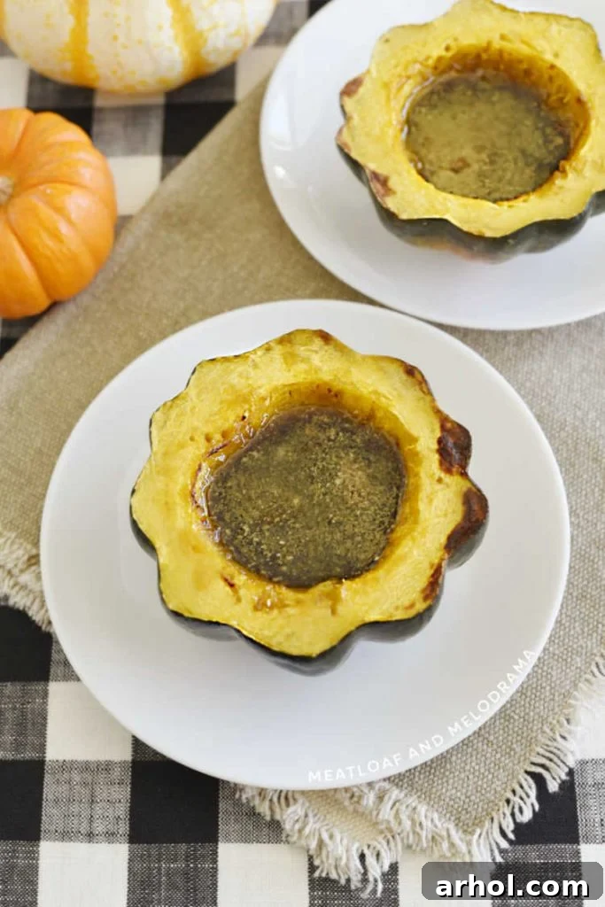 baked acorn squash filled with maple syrup and brown sugar on a plate
