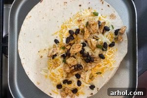 chicken, beans and cheese on tortilla on griddle