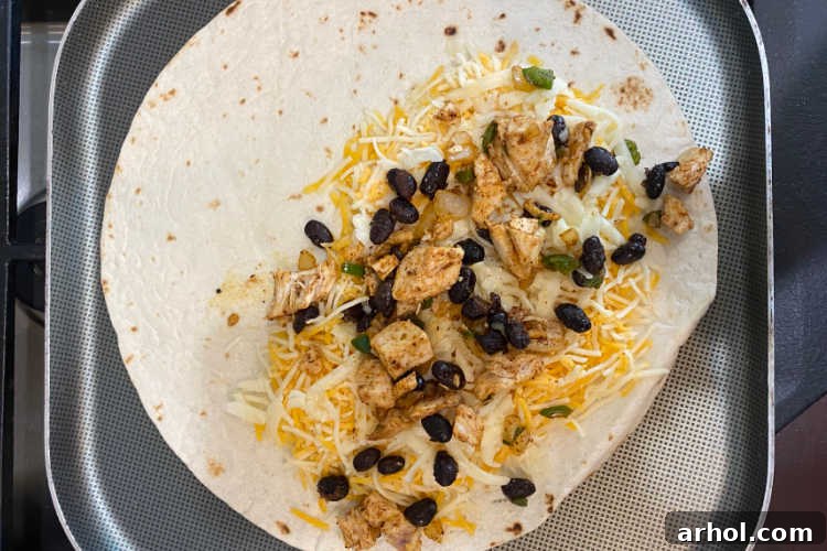 chicken, beans and cheese on tortilla on griddle