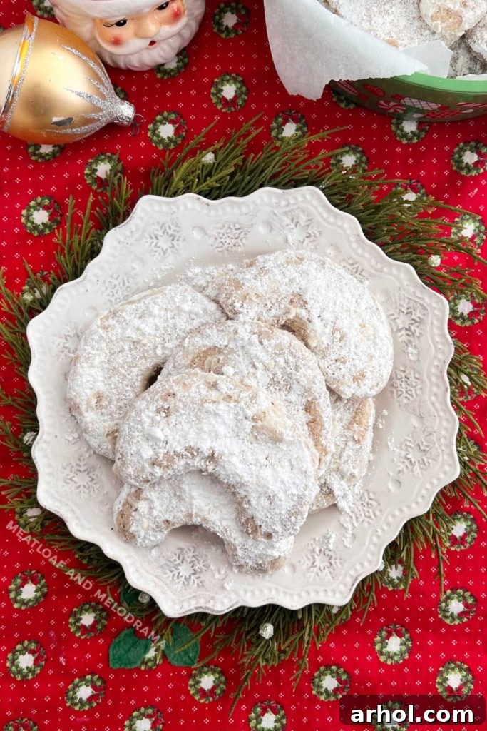 Christmas crescents with powdered sugar arranged on a festive holiday table.