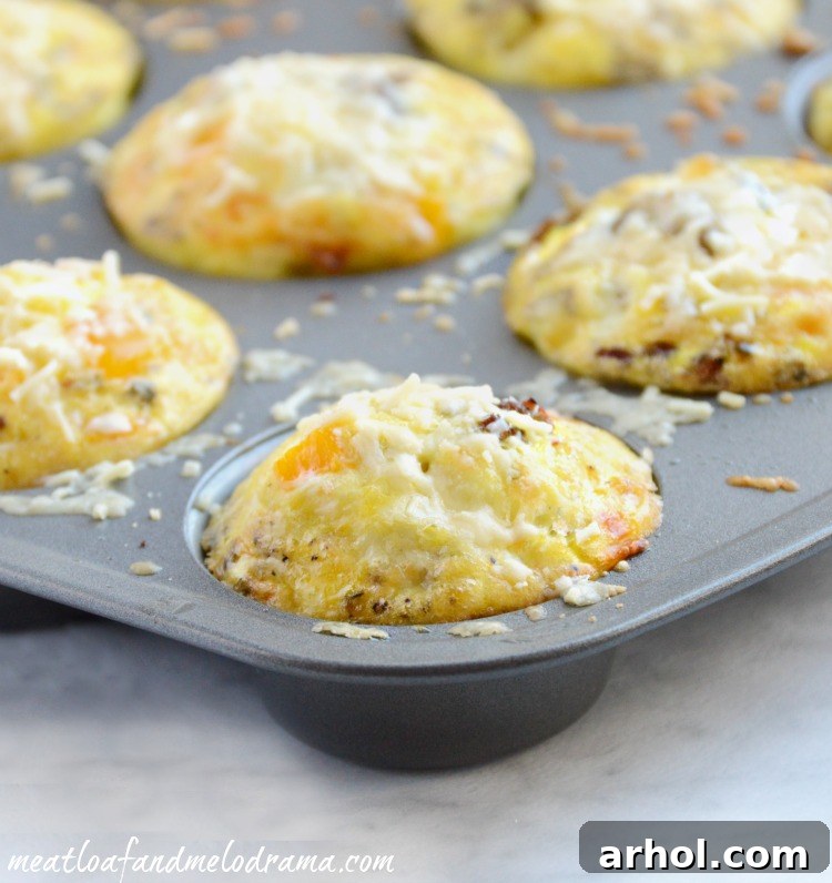Golden Cheesy Sausage Egg Muffins 2 Sausage and Egg Muffin Cups baking in a greased muffin tin