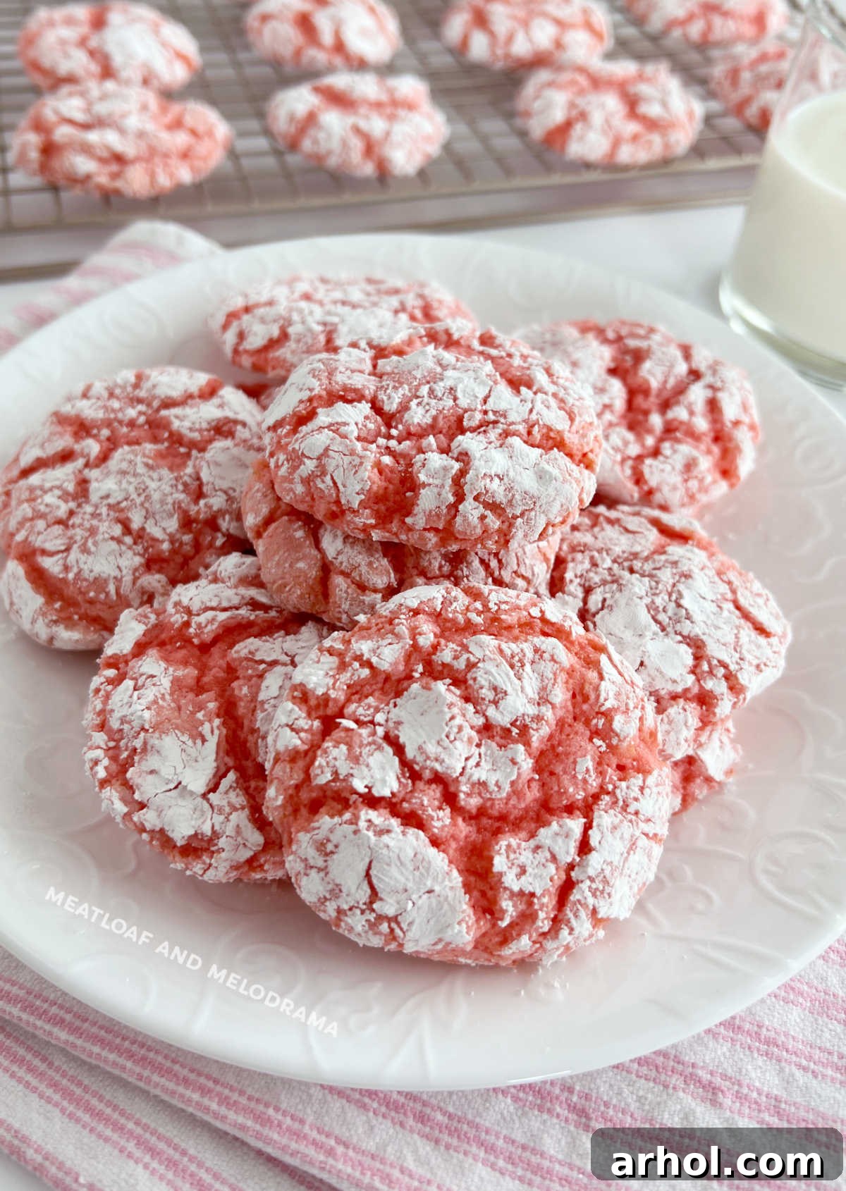A charming plate overflowing with freshly baked strawberry Cool Whip cake mix cookies, glistening with powdered sugar, ready to be enjoyed.