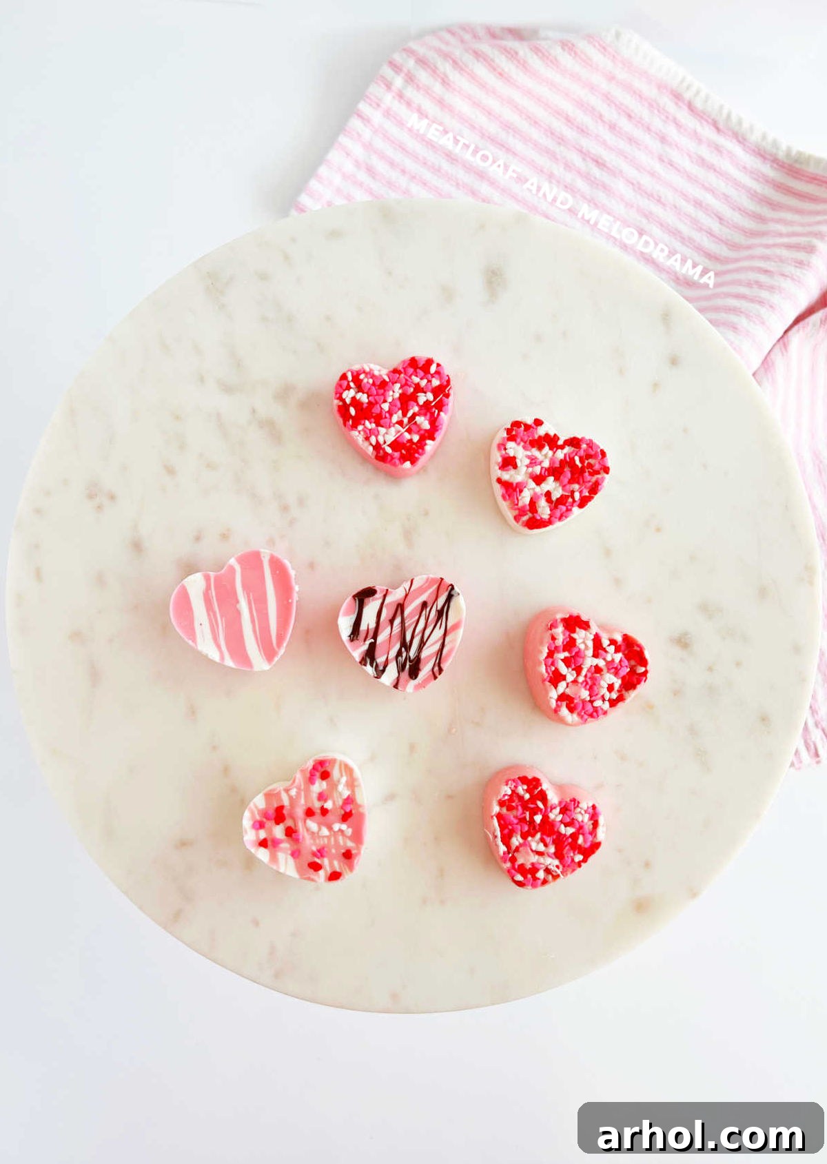 Homemade white chocolate candy hearts decorated with pink and white sprinkles for Valentine's Day
