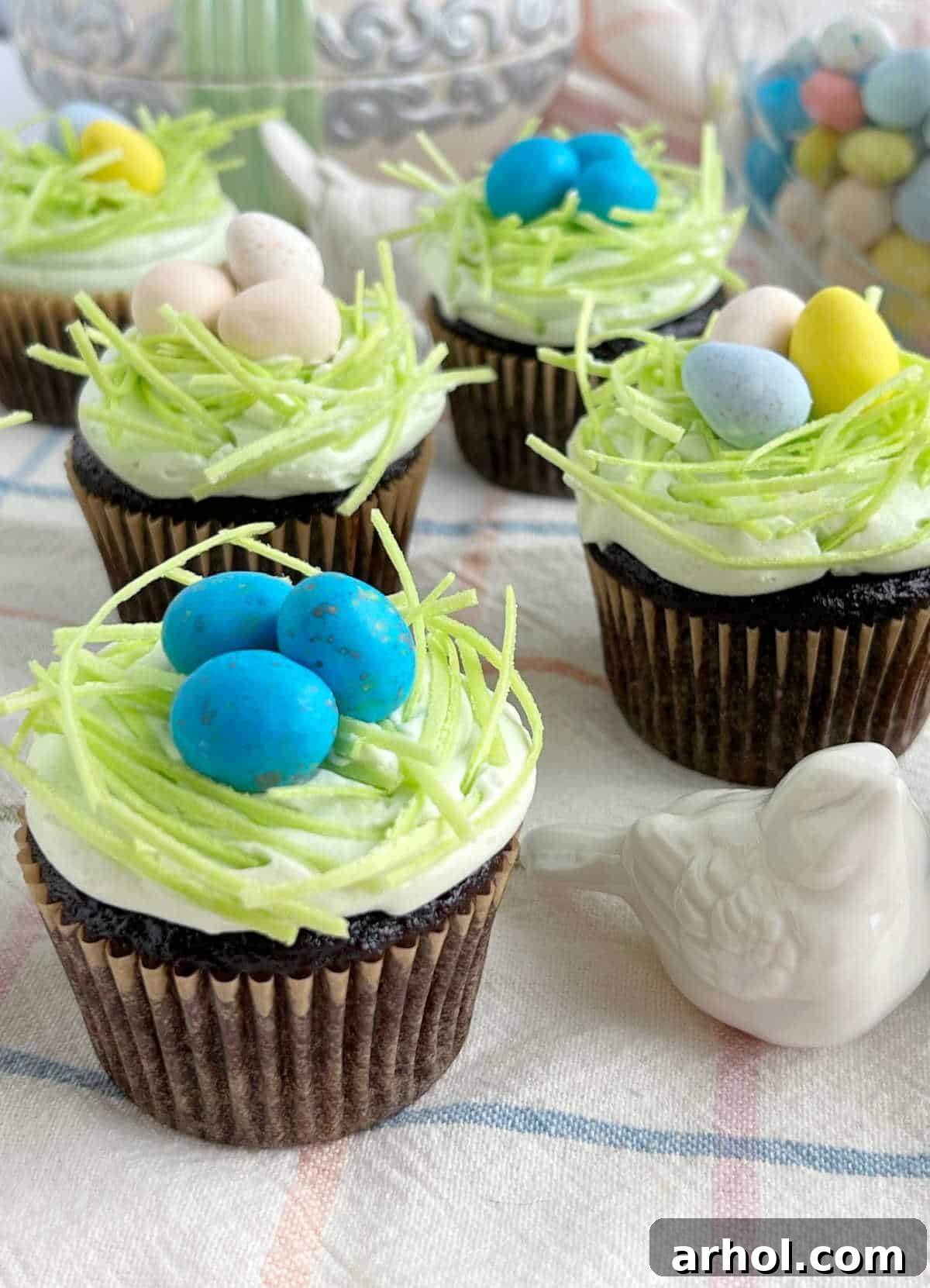 Close-up of adorable Bird's Nest Easter Cupcakes, showcasing vibrant edible grass and colorful mini eggs, perfect for spring festivities.