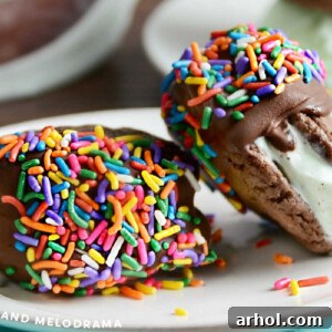mint chocolate chip cookie ice cream sandwiches dipped in chocolate with sprinkles on plate