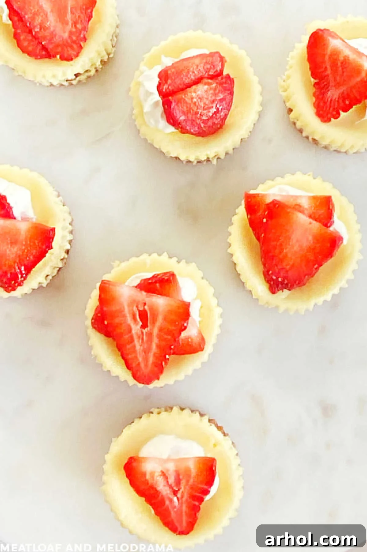 mini cheesecakes with graham cracker crust and fresh strawberry topping