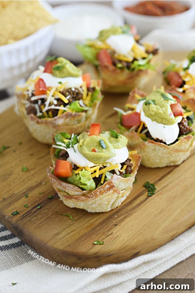 A serving board filled with colorful mini individual taco salads, garnished with fresh toppings and ready to be enjoyed.
