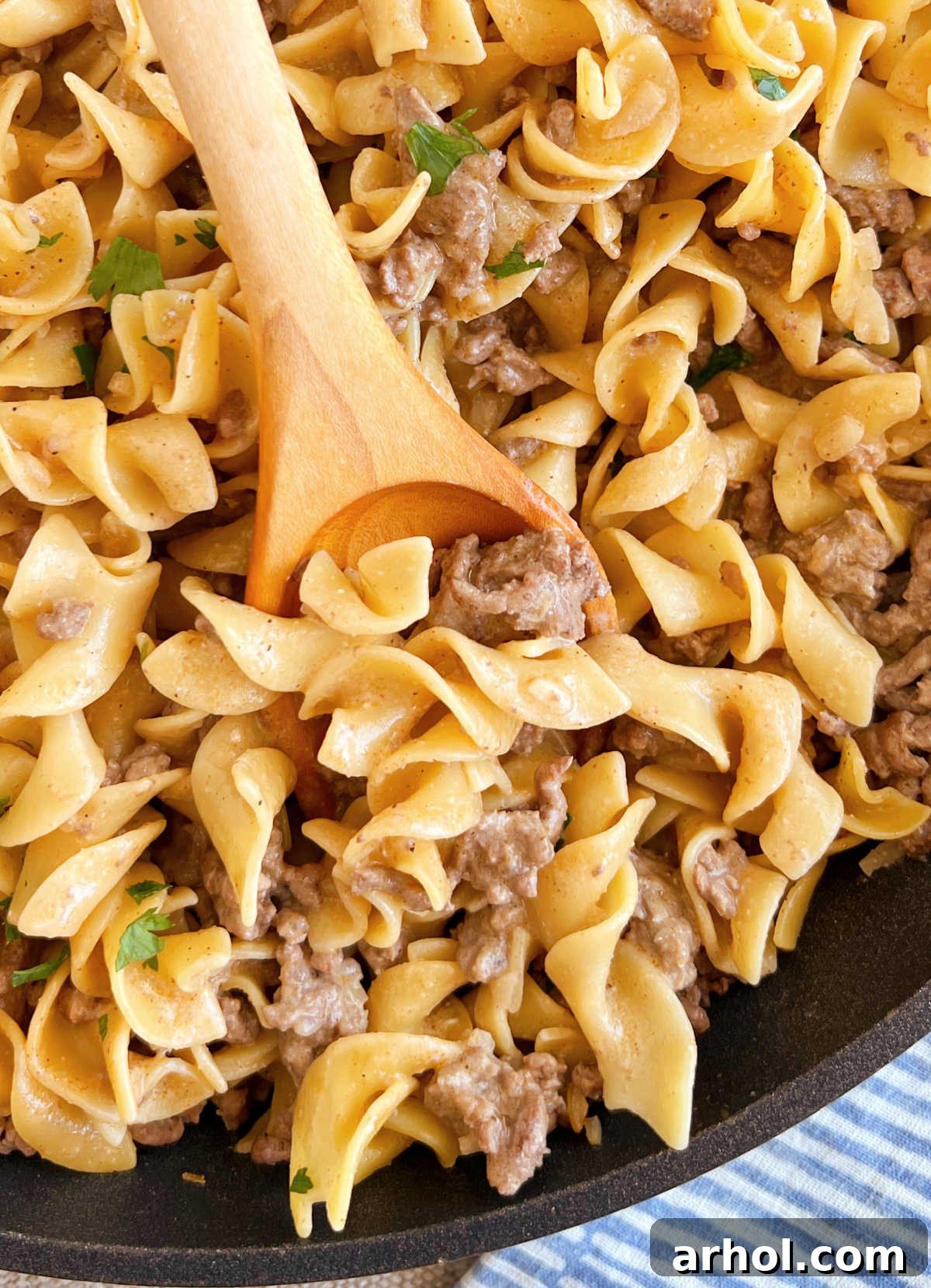 Better-Than-Boxed Ground Beef Stroganoff 2 Homemade Hamburger Helper Beef Stroganoff on a wooden spoon in a skillet