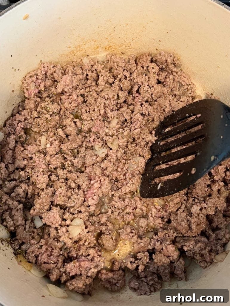 Brown ground beef and onions in a Dutch oven until cooked through.