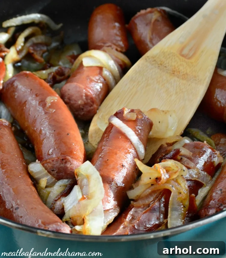 Polish Sausage Dogs and Caramelized Onions cooking in a frying pan