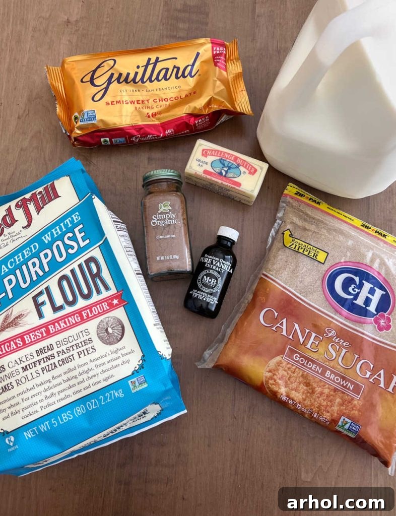 A selection of essential ingredients for edible cookie dough laid out: all-purpose flour, chocolate chips, vanilla extract, ground cinnamon, softened butter, milk, and brown sugar.