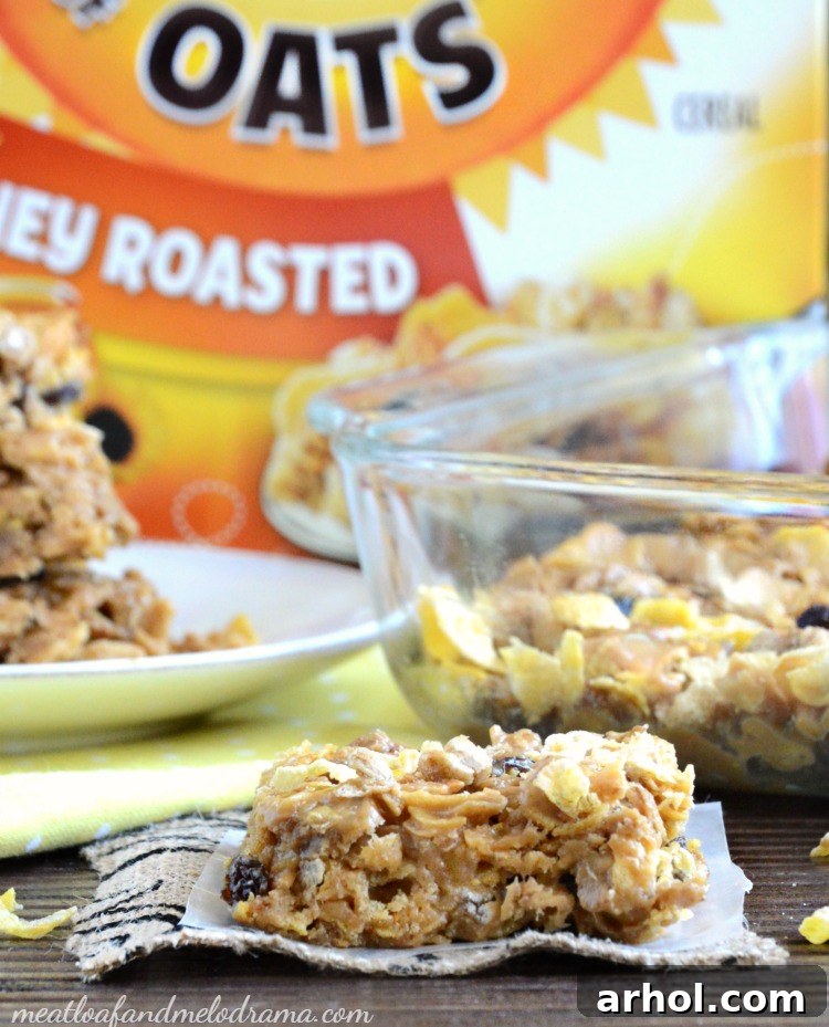 Close-up view of a pan filled with freshly made no-bake peanut butter honey oat cereal bars before slicing, showcasing their appealing texture and golden-brown hue.