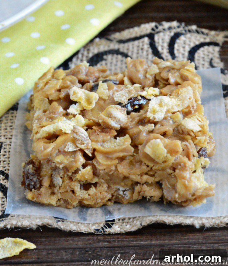Close-up shot of several homemade Peanut Butter Honey Oat Cereal Bars stacked, showing the chewy and crunchy texture with visible cereal flakes and raisins.