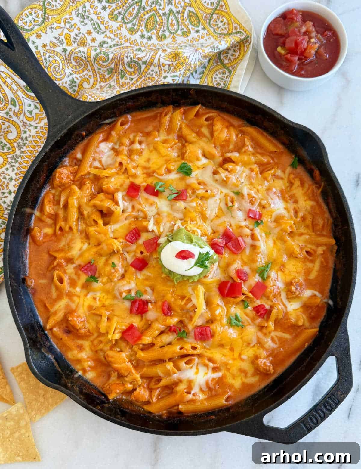 Delicious one-pan creamy chicken enchilada pasta in a skillet, garnished with fresh cilantro and ready to serve.