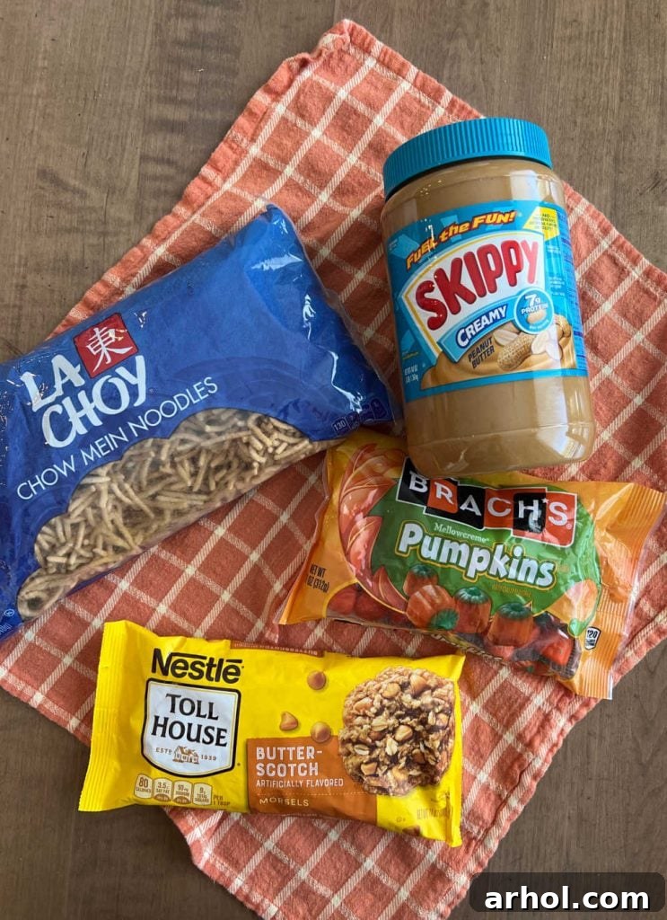 Essential ingredients for no-bake haystacks: crunchy chow mein noodles, creamy peanut butter, rich butterscotch morsels, and cute marshmallow pumpkins.