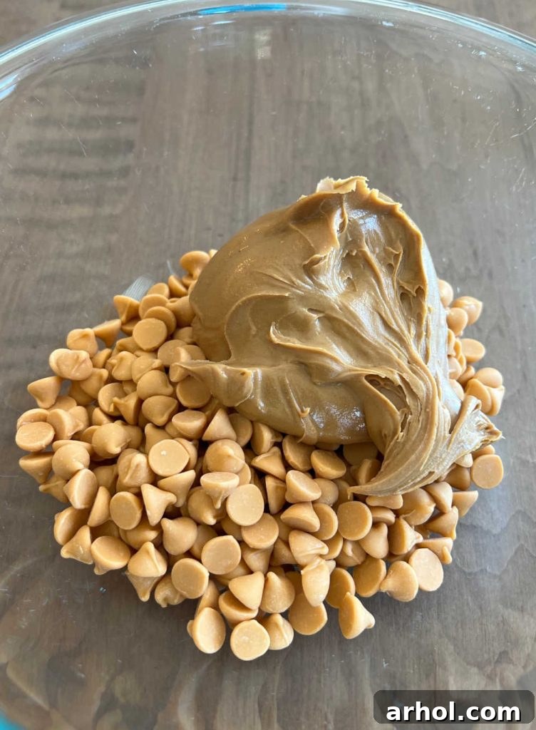 Smooth, melted butterscotch morsels and creamy peanut butter expertly combined in a bowl, forming the delicious base for haystack cookies.