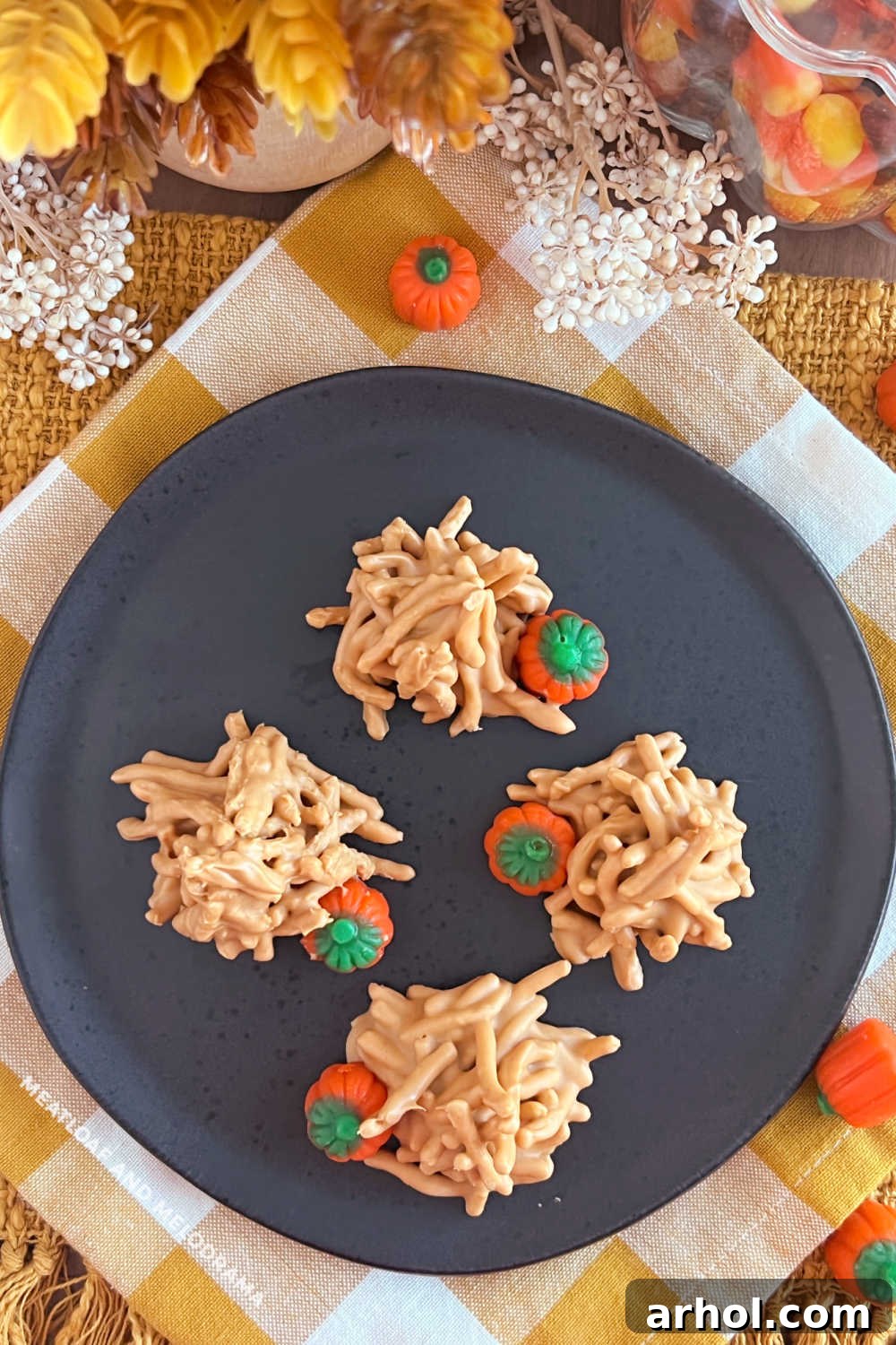 An inviting overhead shot of butterscotch haystack cookies, beautifully topped with festive marshmallow pumpkins, arranged on a tray.