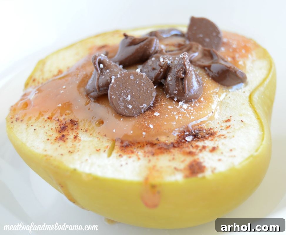 Baked apples with caramel in the middle, topped with melting chocolate chips and a sprinkle of sea salt, ready for serving.