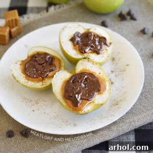 Baked chocolate caramel apple halves topped with sea salt on a plate, a delightful fall dessert.