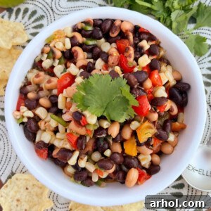 Delicious Black Eyed Pea Salsa (Cowboy Caviar) served in a white bowl, garnished with fresh cilantro and ready for dipping.