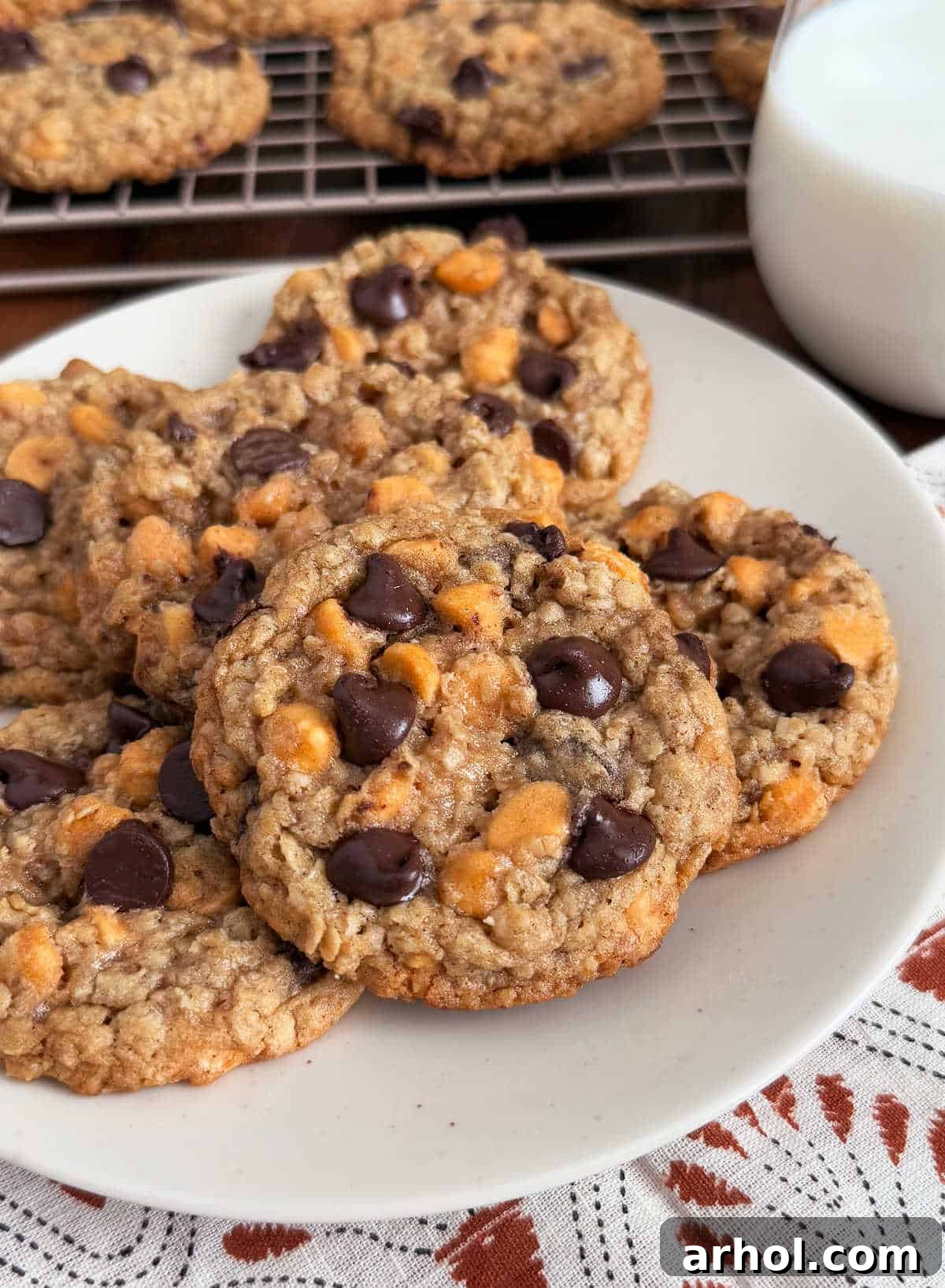 A beautifully arranged plate of golden-brown oatmeal butterscotch chocolate chip cookies, showcasing their chewy texture and abundance of chips.