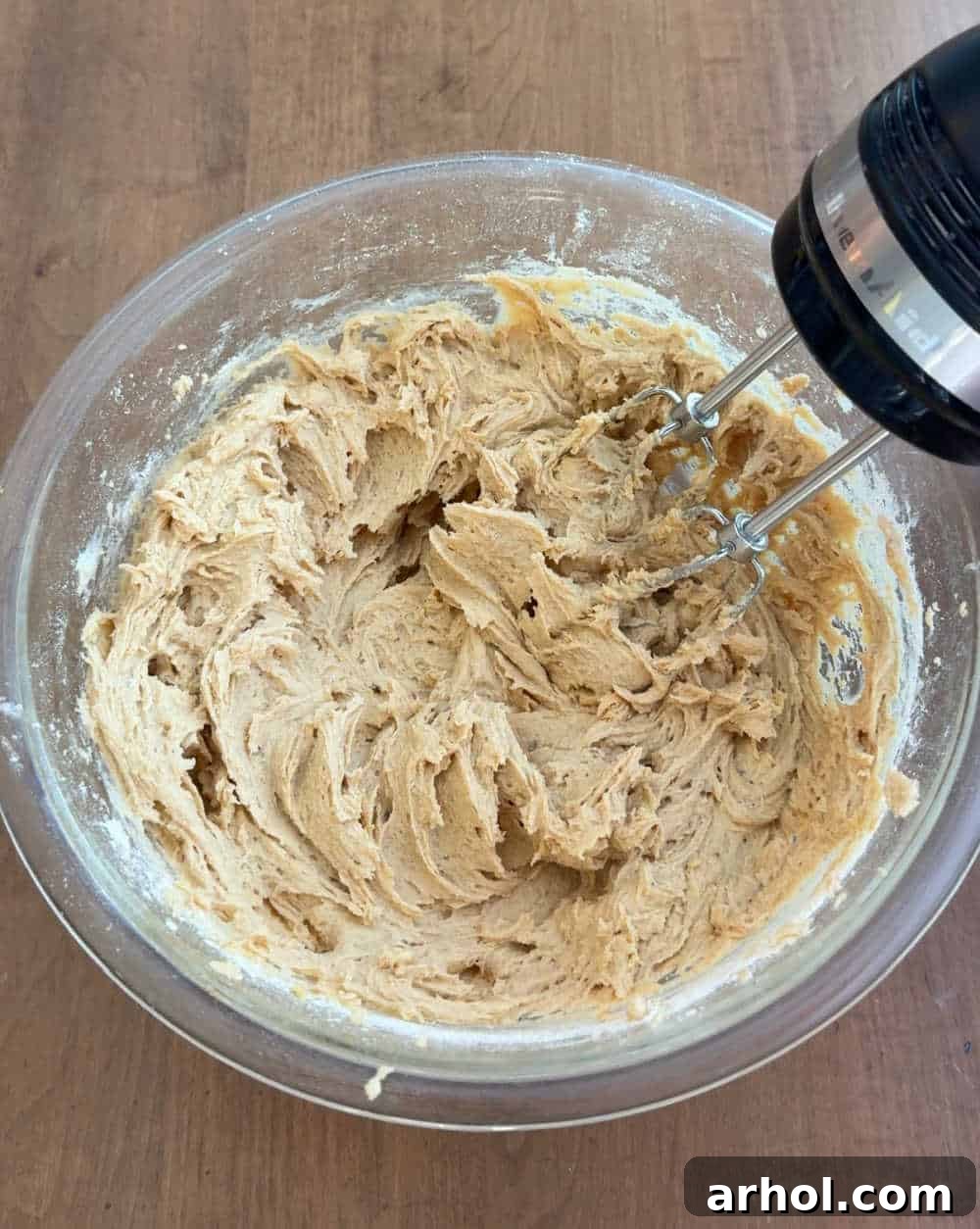 Mixing the wet ingredients (creamed butter, sugars, and vanilla) in a large bowl, showing a smooth and fluffy texture.