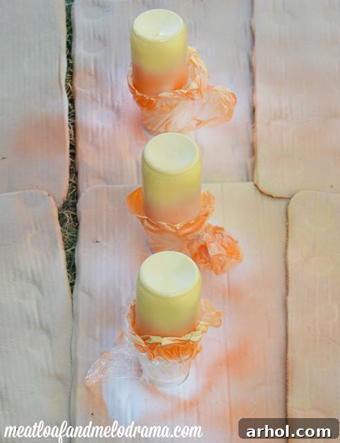 Glass bottles with orange, yellow, and white spray paint forming candy corn design