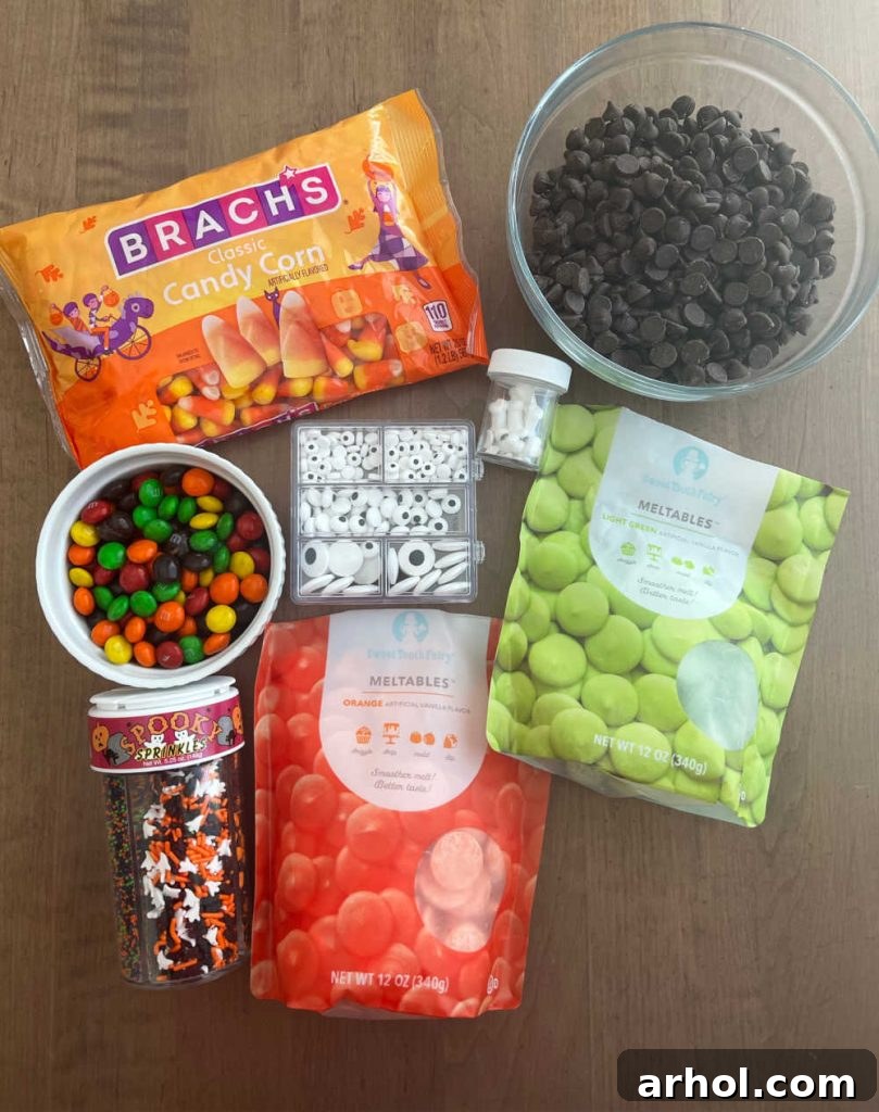 A vibrant assortment of Halloween candy bark ingredients displayed: colorful candy melts, classic candy corn, rich chocolate chips, playful candy eyeballs, and various Halloween-themed candies.