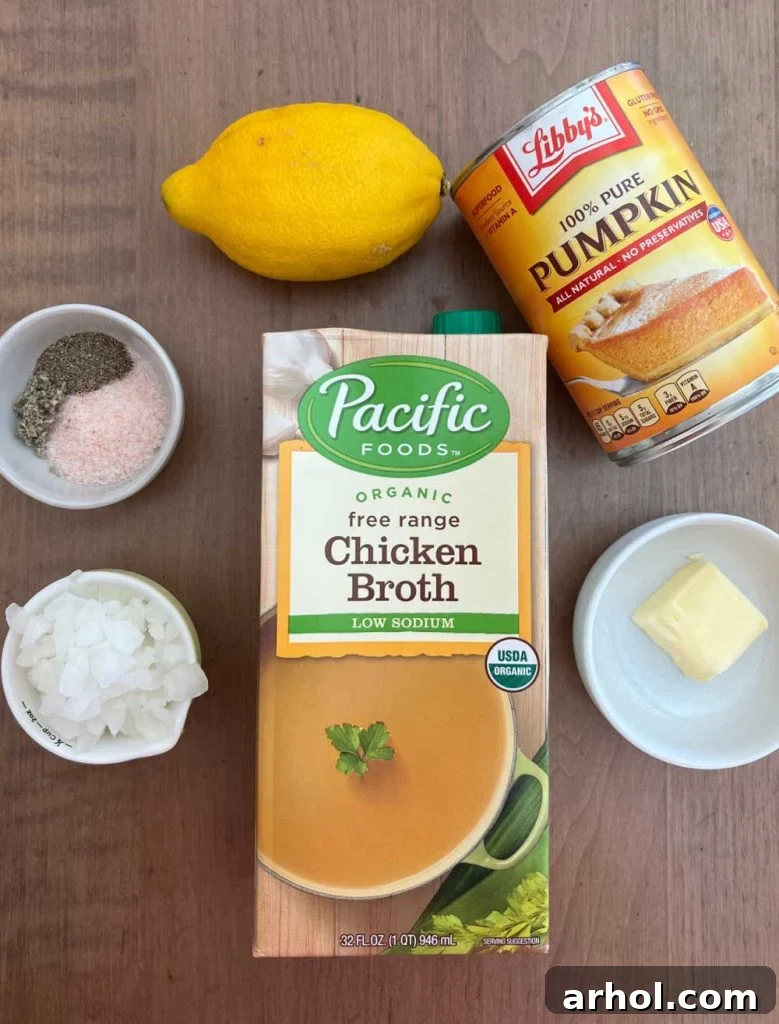libby's pumpkin puree, lemon, chicken broth, butter, onion and seasonings laid out on a table, ready for making soup