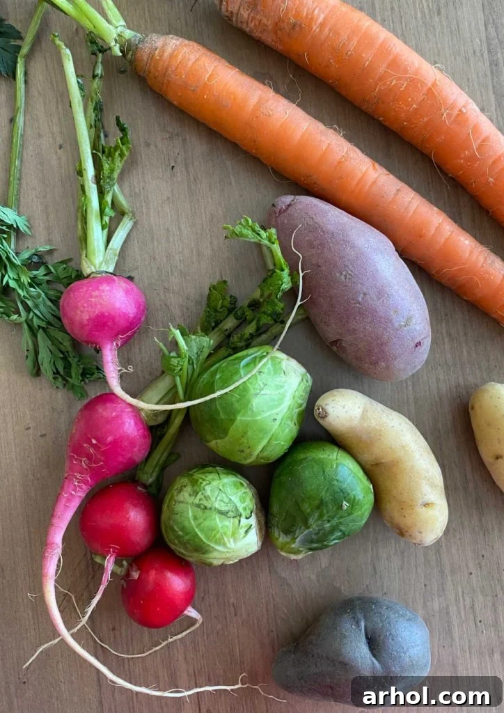 Raw, colorful carrots, radishes, Brussels sprouts, and fingerling potatoes arranged on a wooden table, ready for preparation.