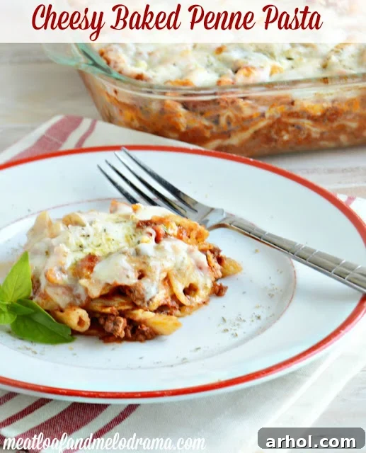Overhead view of a large baking dish filled with Cheesy Baked Penne Pasta, showing the rich red sauce, ground beef, and golden-brown melted mozzarella and Parmesan cheese.